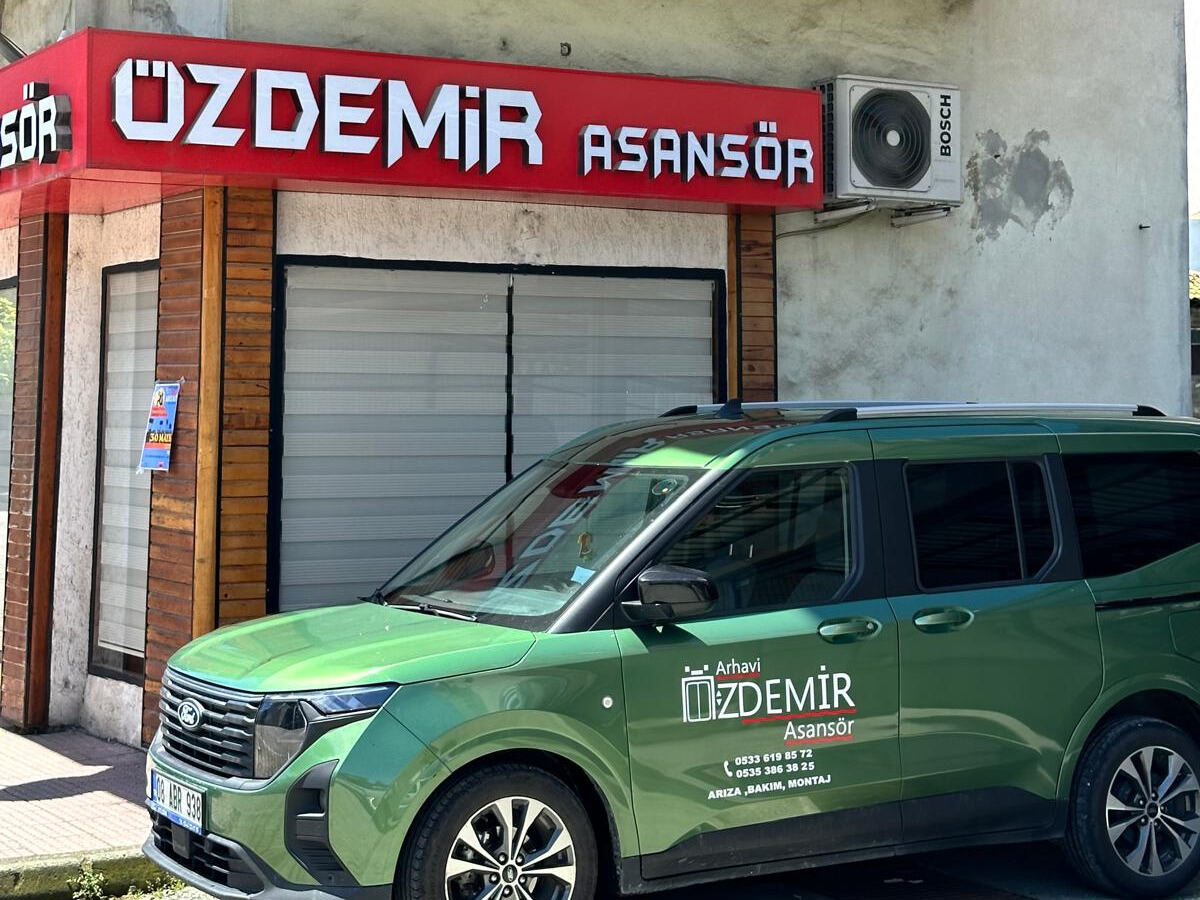 Özdemir Asansör iş yeri: kırmızı ÖZDEMİR ASANSÖR tabelası ve firma aracı