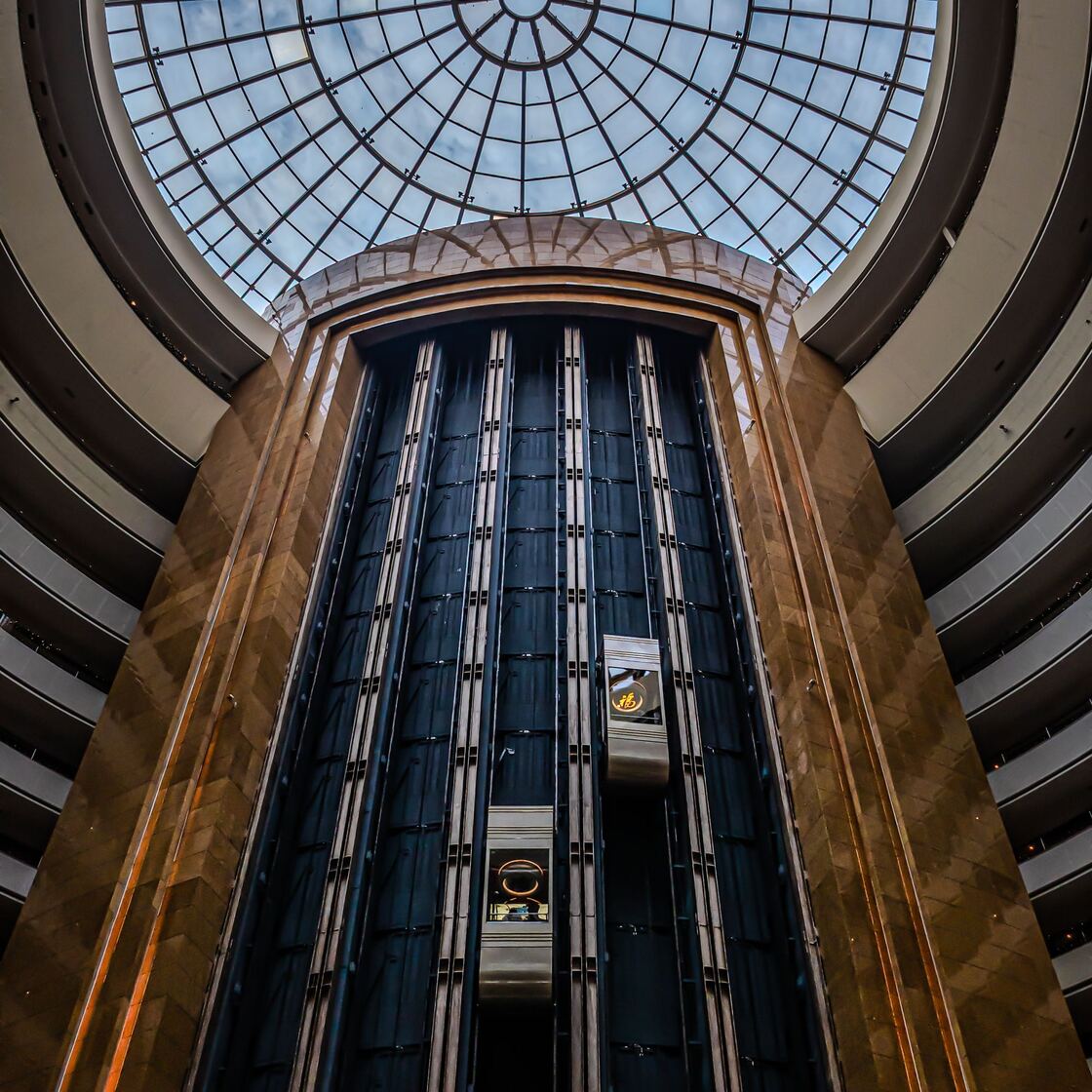 Bir binanın atriumunda cam kabinli panoramik asansör